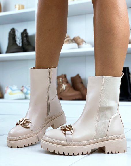Beige ankle boots adorned with a golden chain