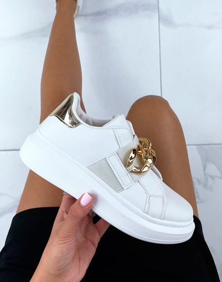 Beige sneakers adorned with a golden chain