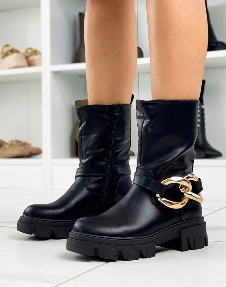 Black ankle boots with large golden chain and notched sole