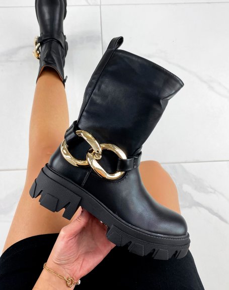 Black ankle boots with large golden chain and notched sole