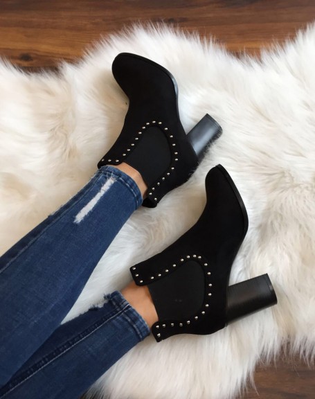 Black Chelsea boots adorned with studs and heels