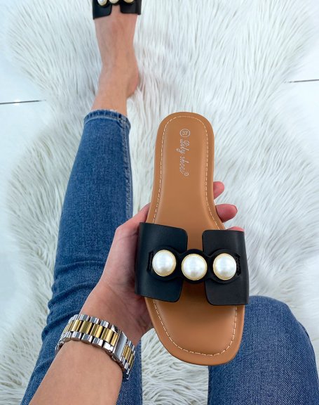 Black flat mules adorned with chunky pearls