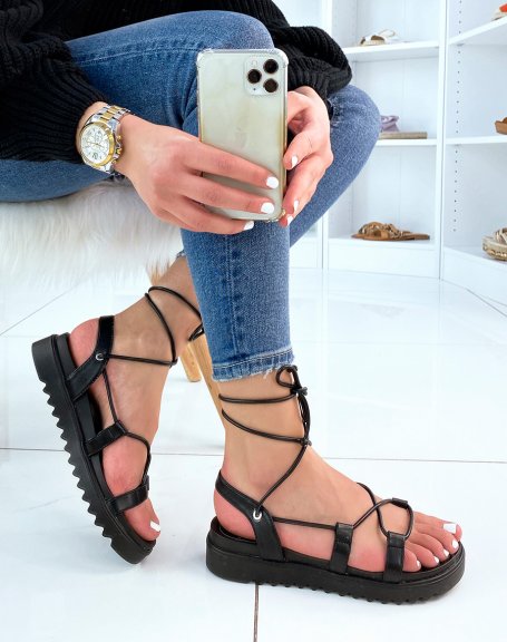 Black flat sandals with long straps and notched sole