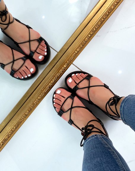 Black flat sandals with long straps and notched sole