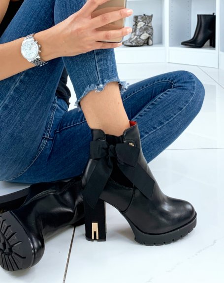 Black heeled ankle boots decorated with a bow