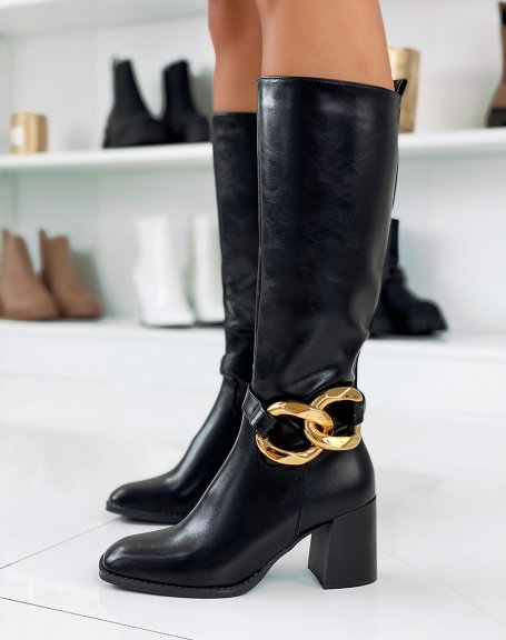 Black high heeled boots adorned with a gold chain