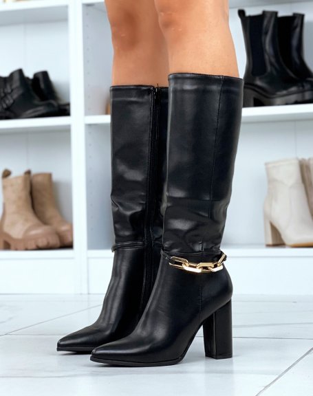 Black high heeled boots adorned with a golden chain