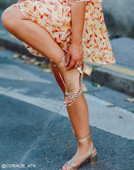 Golden sandals with low heel and long straps