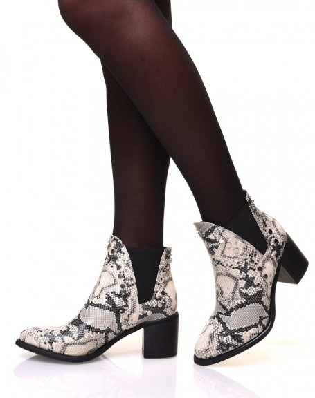 Heeled ankle boots with snake patterns and studded details