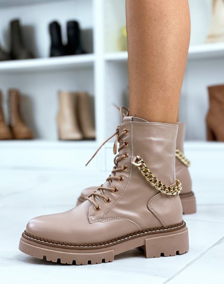 High beige ankle boots adorned with a golden chain