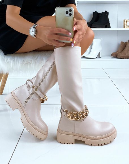 Tall beige boots adorned with a golden chain