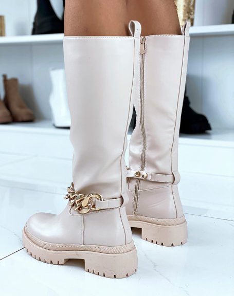 Tall beige boots adorned with a golden chain