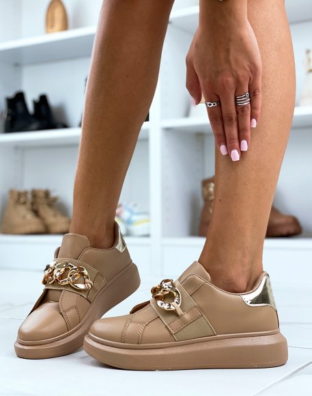 Taupe sneakers adorned with a golden chain