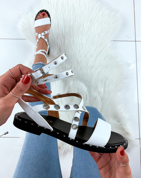 White faux leather slippers with crisscrossing straps and studs