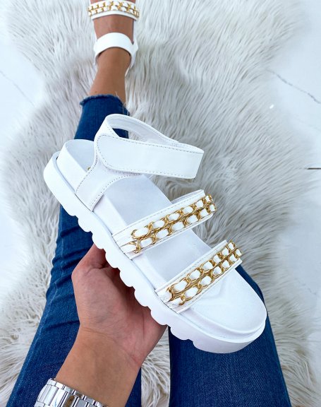White flat sandals with chunky straps and golden chains