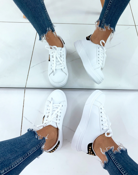 White sneakers with black inserts adorned with studs