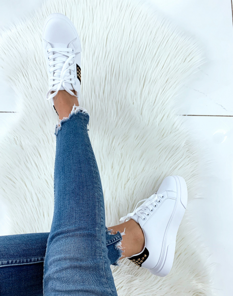 White sneakers with black inserts adorned with studs