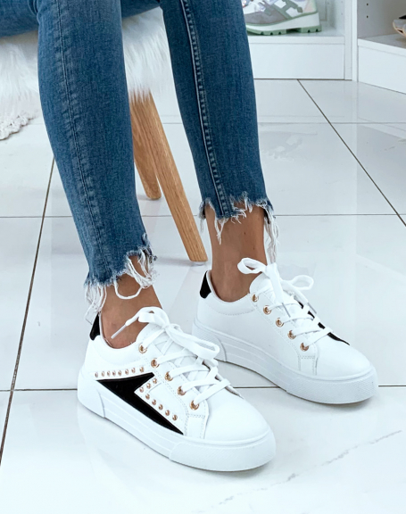 White sneakers with multiple black suede inserts adorned with studs