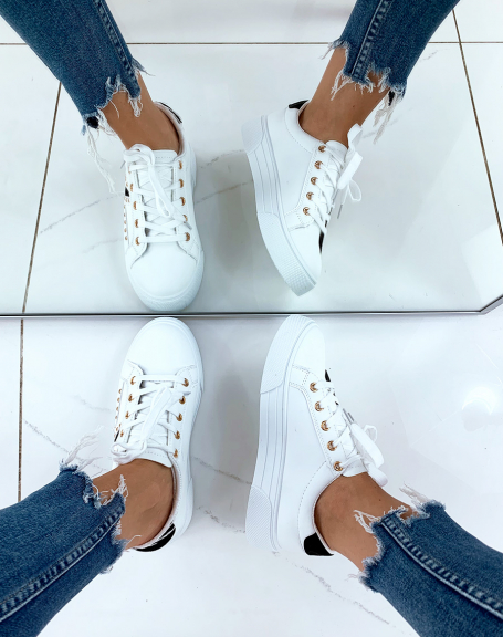 White sneakers with multiple black suede inserts adorned with studs