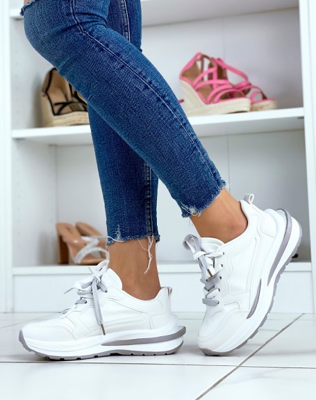 White sneakers with multiple gray and white inserts with large sole