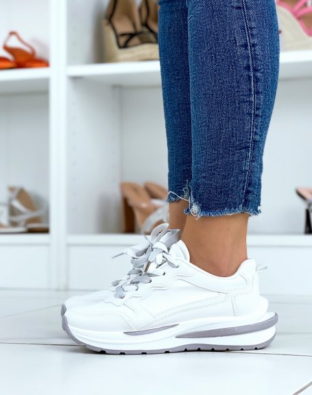 White sneakers with multiple gray and white inserts with large sole