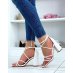 White sandals with intersecting straps and rounded heel